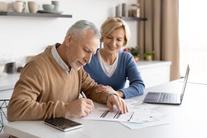 Old couple with laptop and papers