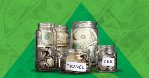 Glass jars labeled with savings goals like "TRAVEL" and "CAR," filled with bills and coins, set against a background of US dollar bills, illustrating envelope budgeting for financial wellness.